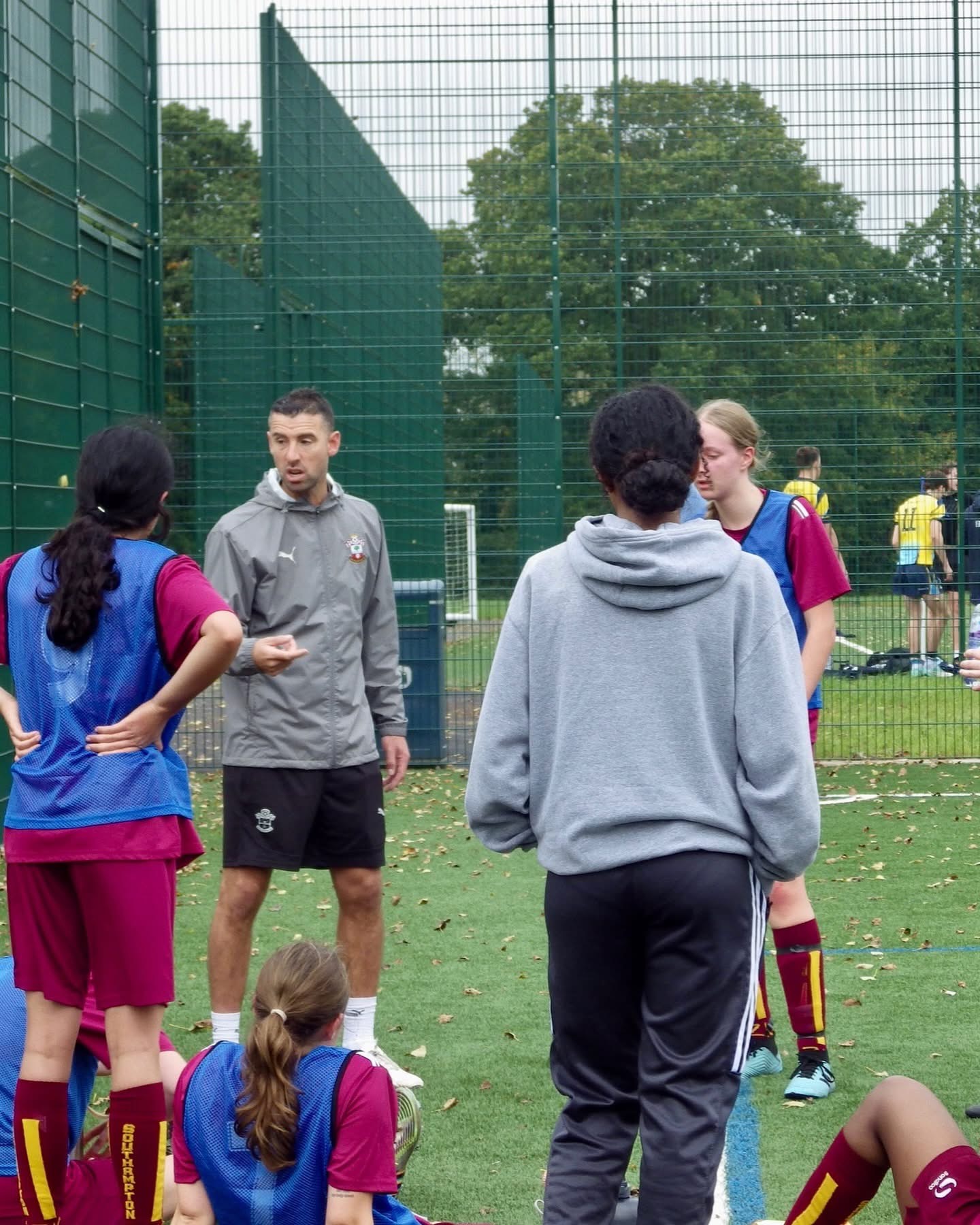 Dave discussing coaching points with players on the pitch